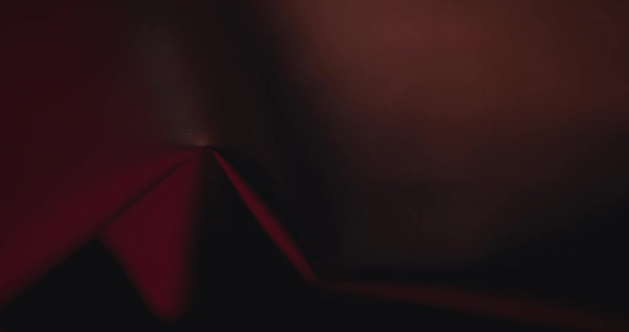 Beam of light under a red abstract metallic object lifting the shading