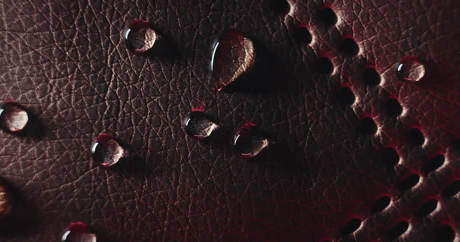 Water droplets over textured brown leather