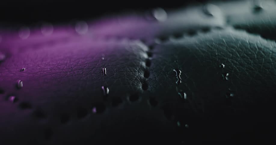 Closeup of water droplets on black leather