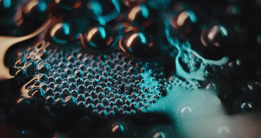Air bubbles floating on the surface of a dark liquid