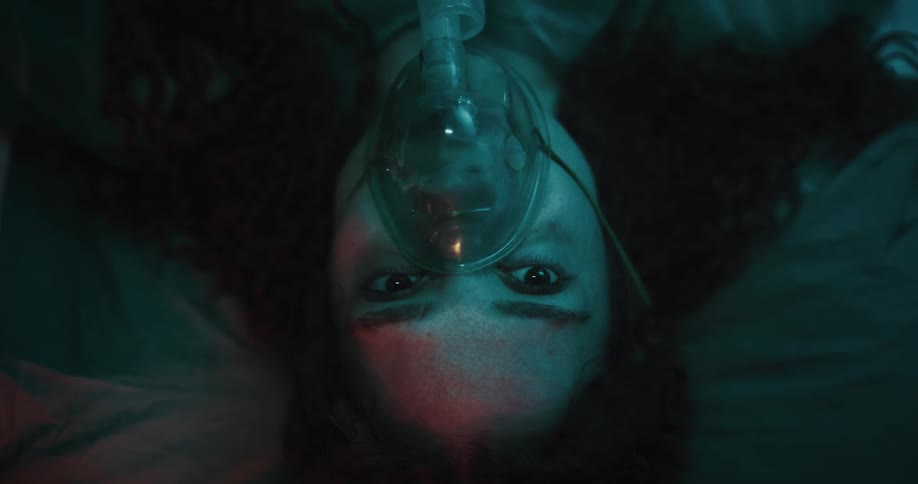 Portrait of a patient waking up with an oxygen mask and looking startled
