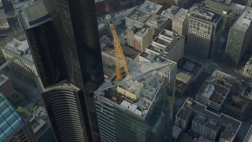 A large crane is on top of a building in a city