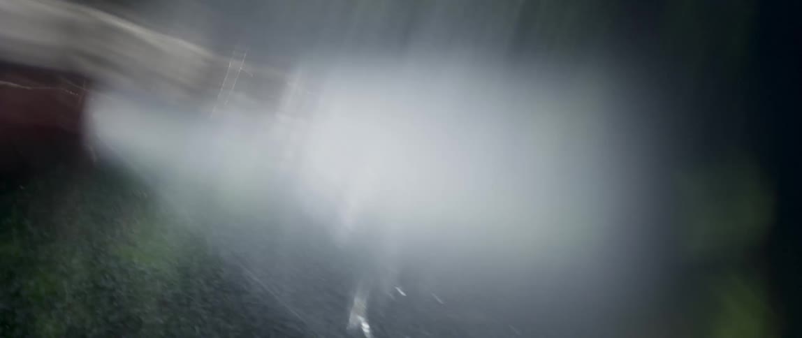 A person uses a hose to wet their hand and several drops of water fly to the sides
