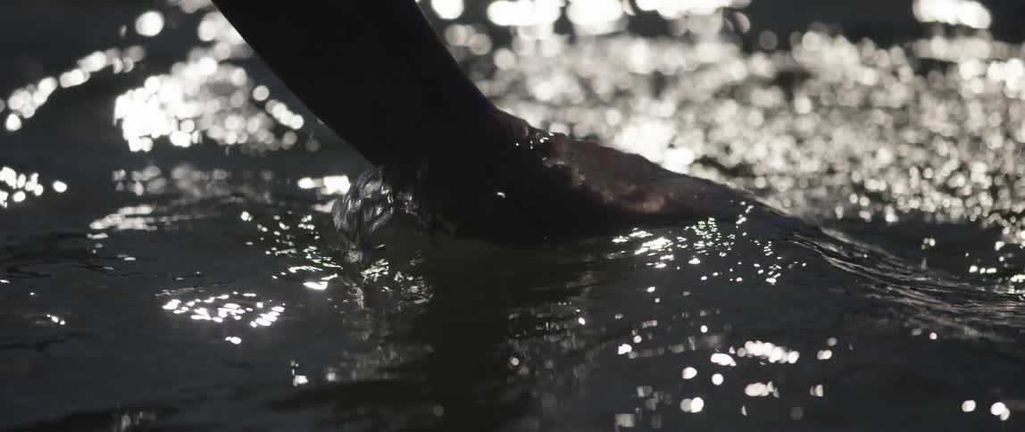 A person hand splashing the water left and right