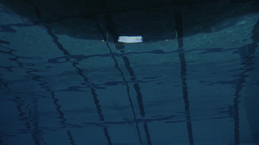 Underwater view of a swimming pool with lane dividers and lights