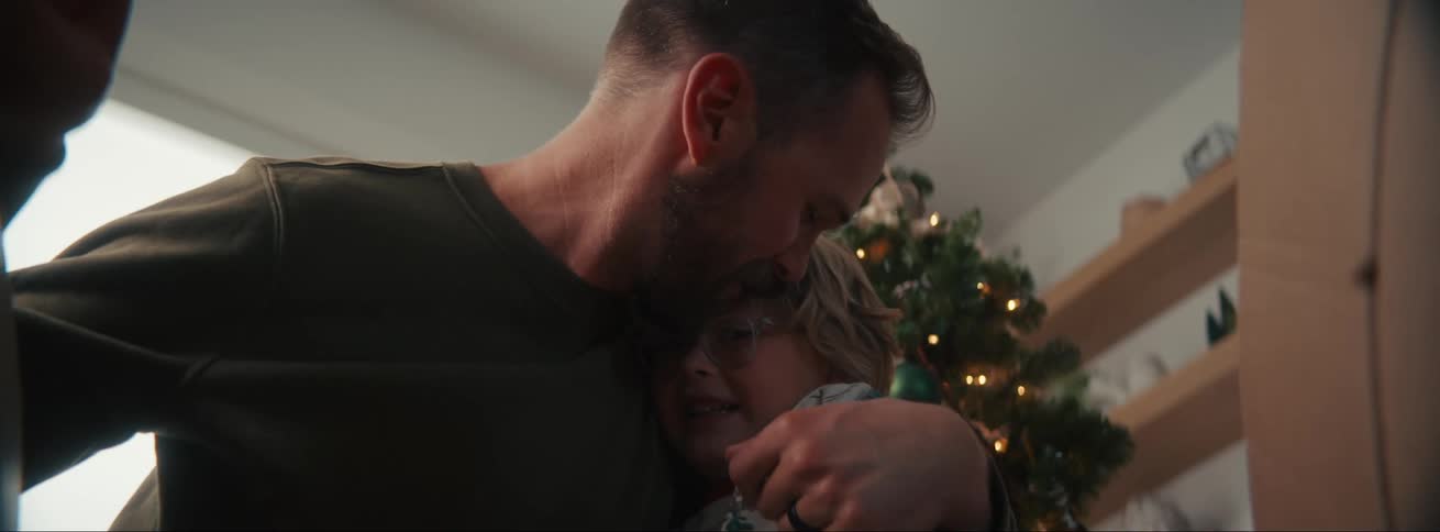 Father opening a box with his children becoming very happy and hugging them