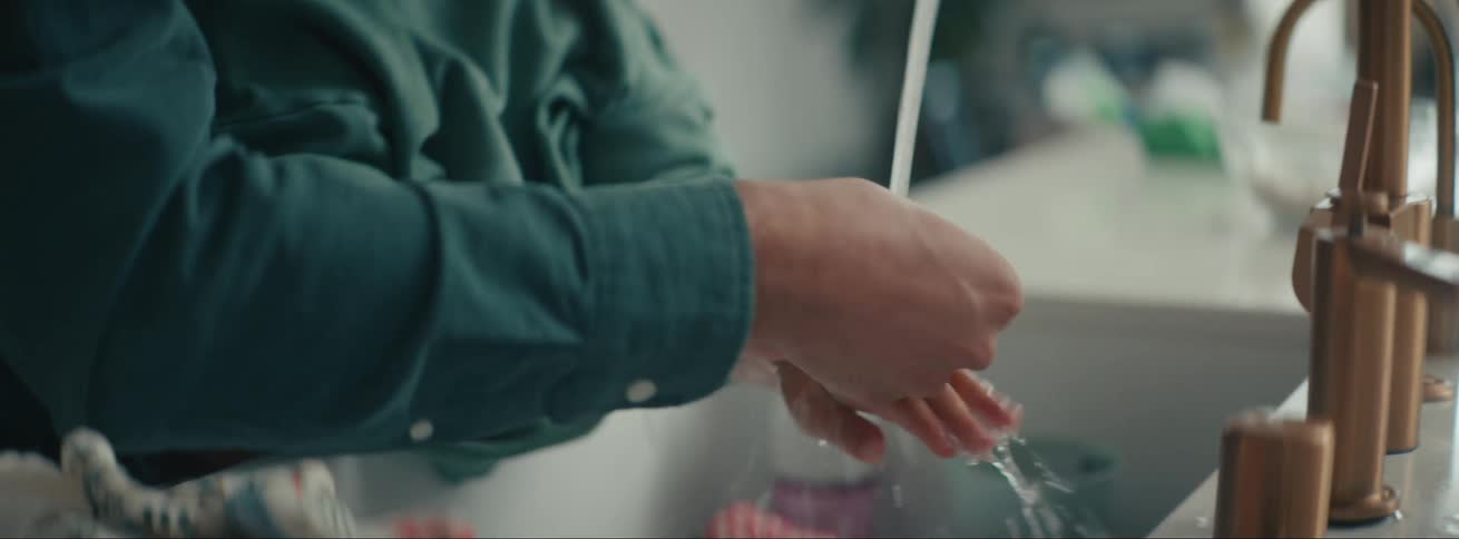 A clip of a father and soon washing the hands and face in a wash hand basin