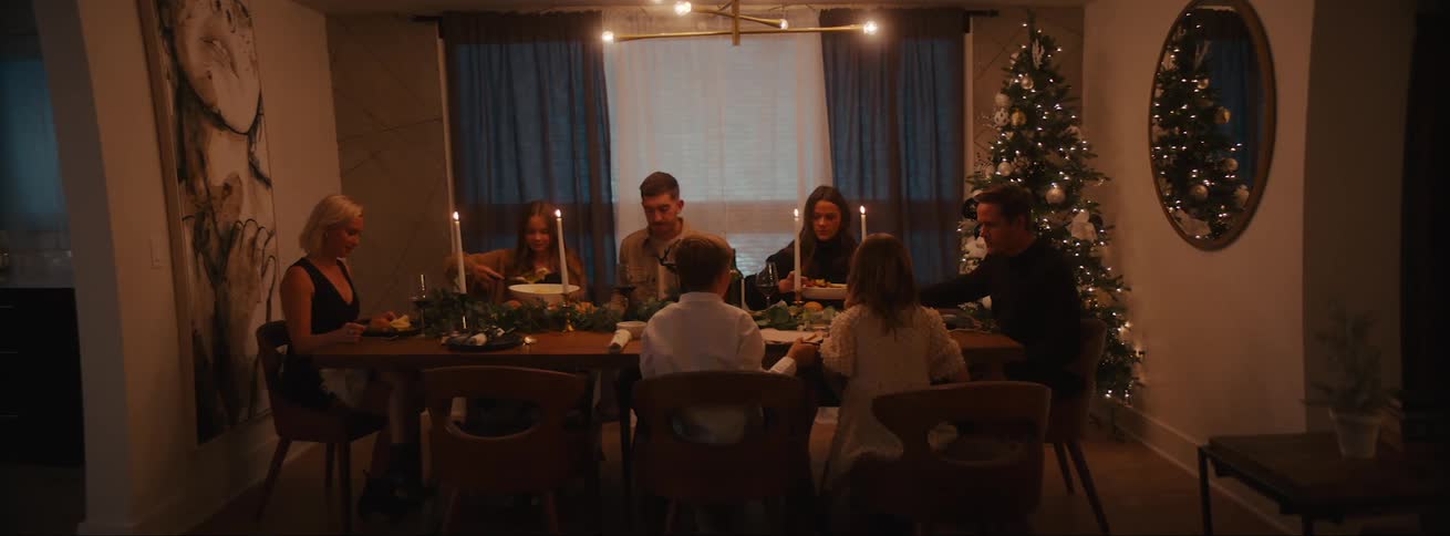 A family dinner with adults and children on the dining with candles lit up