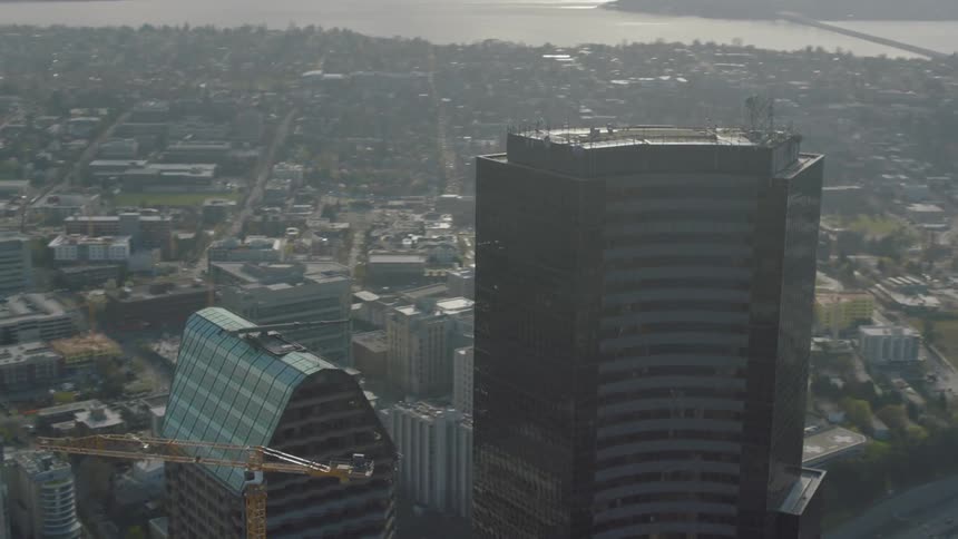 A very tall building has a crane next to it