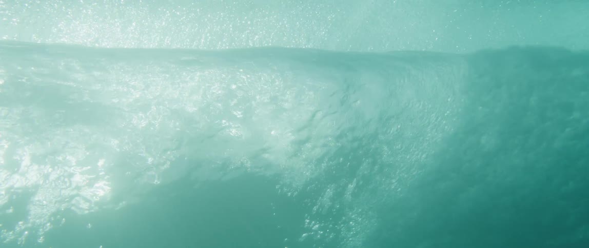View from inside the sea of a moving wave with reflections of sunlight