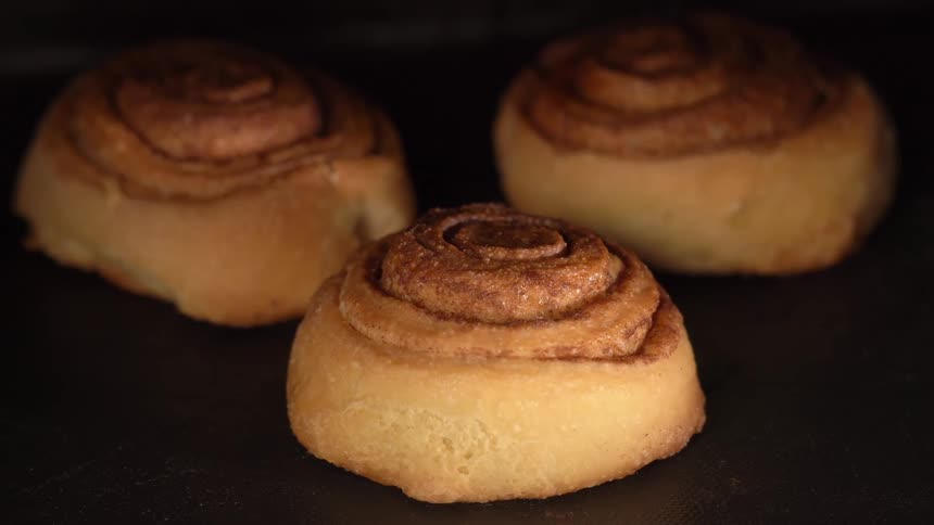 Cinnamon rolls rise as they bake in the oven