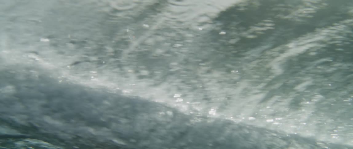 View from inside the sea with a surfboard passing by
