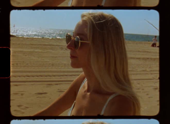 Portrait of a young blonde woman riding a bicycle on the beach sand