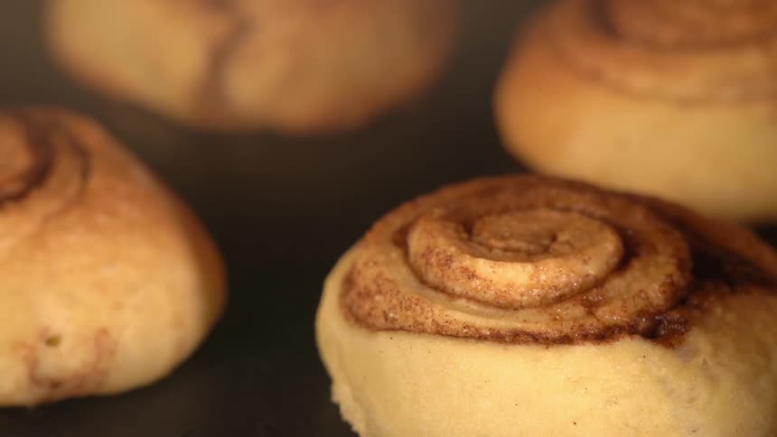 A closeup of cinnamon rolls arranged on a tray