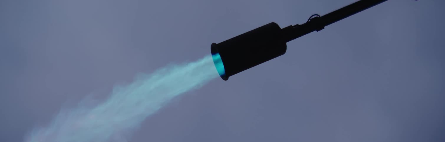 Closeup of a black pipe spewing fire