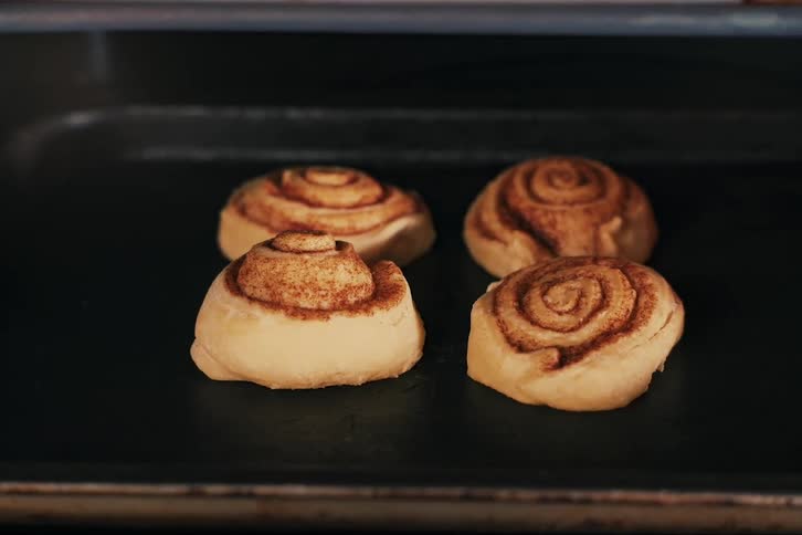 View of four small sweet pastries being baked in time lapse