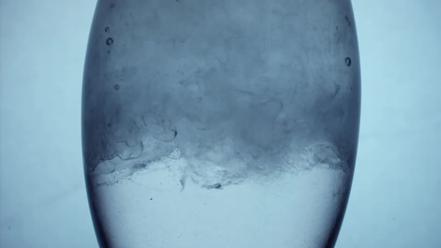 Abstract clear liquid swirling in glass
