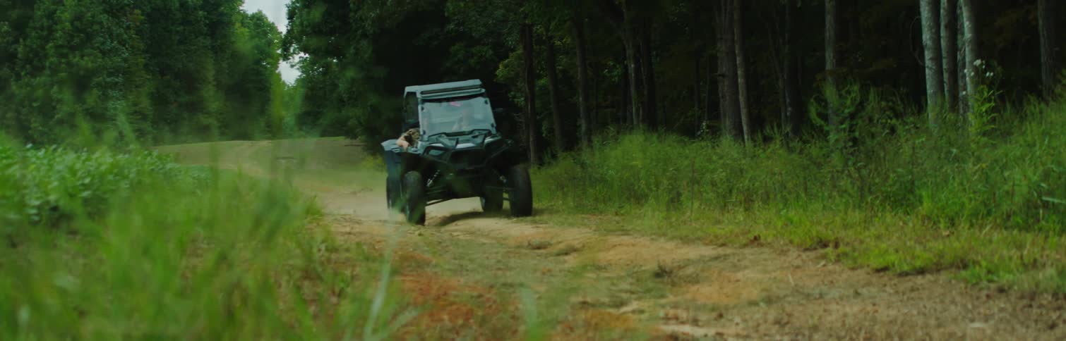 A small sports car on the dirt road in the forest