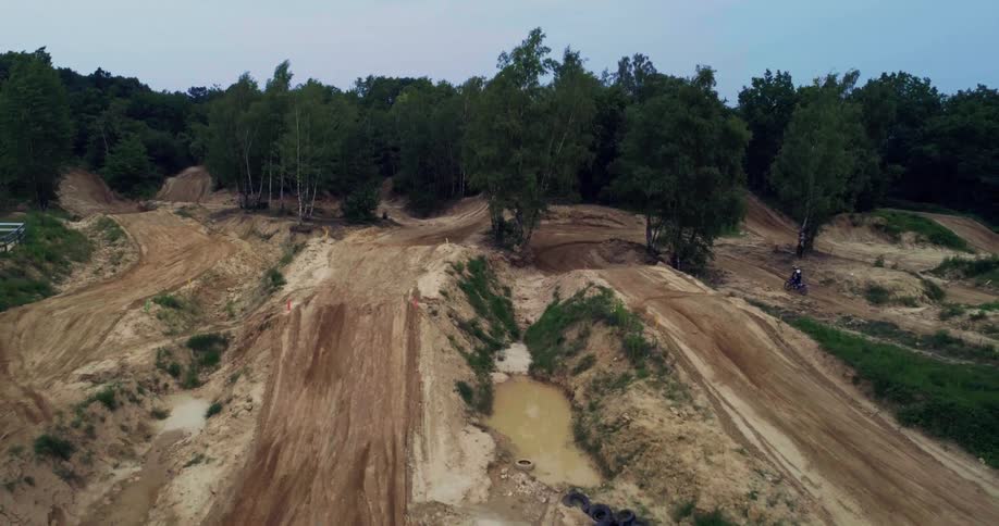 Aerial panorama of a natural motocross track with a person navigating the course
