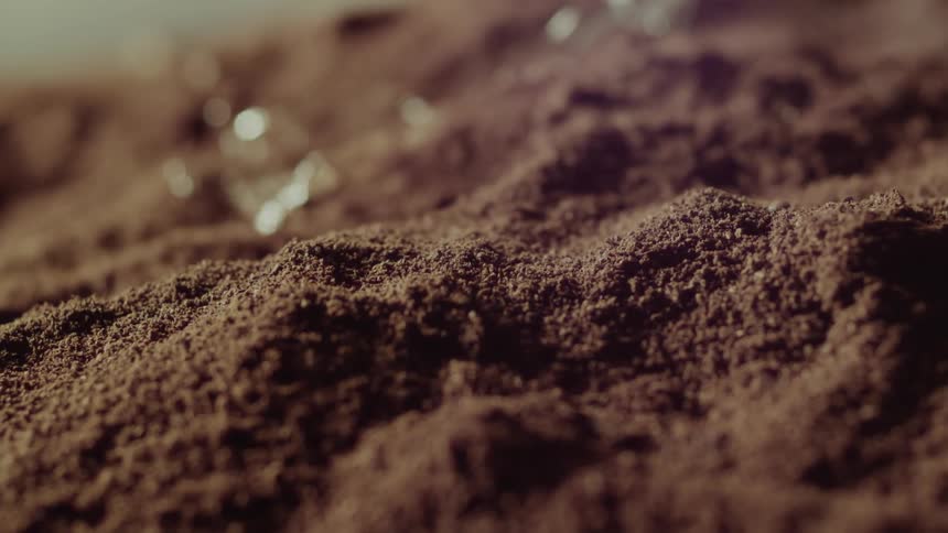 Water falling onto mudcovered ground in slow motion