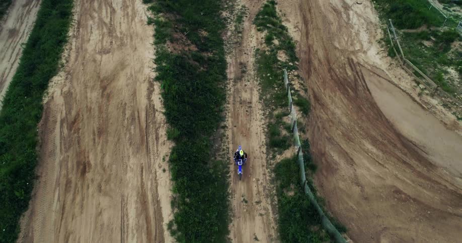 Person practicing motocross on a track in the midst of nature