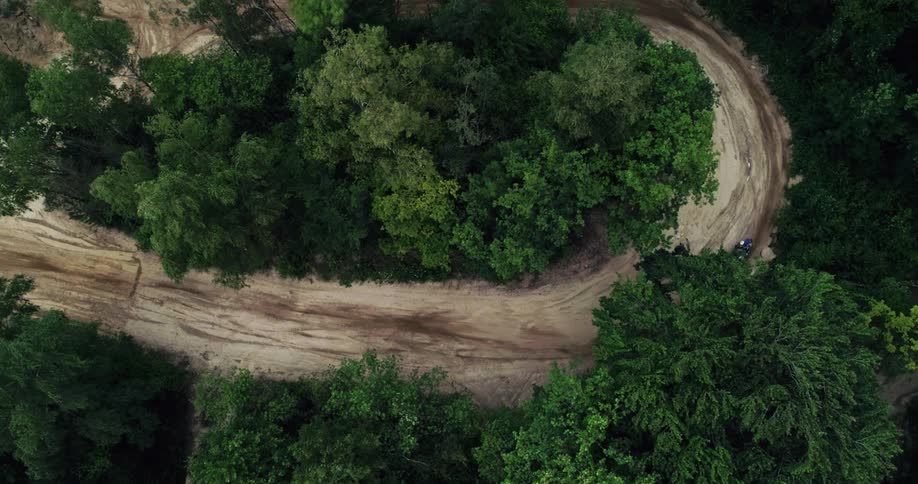 View of a track in nature with a person riding a motocross bike
