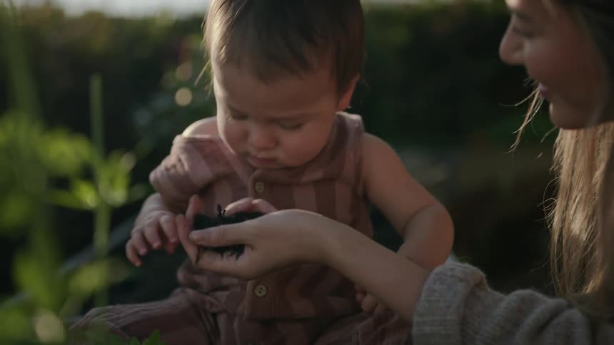 A mother is showing soil to her son