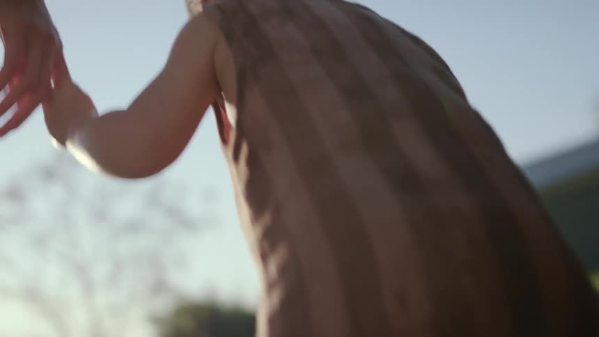 A baby walking barefoot in the garden during the sunny morning