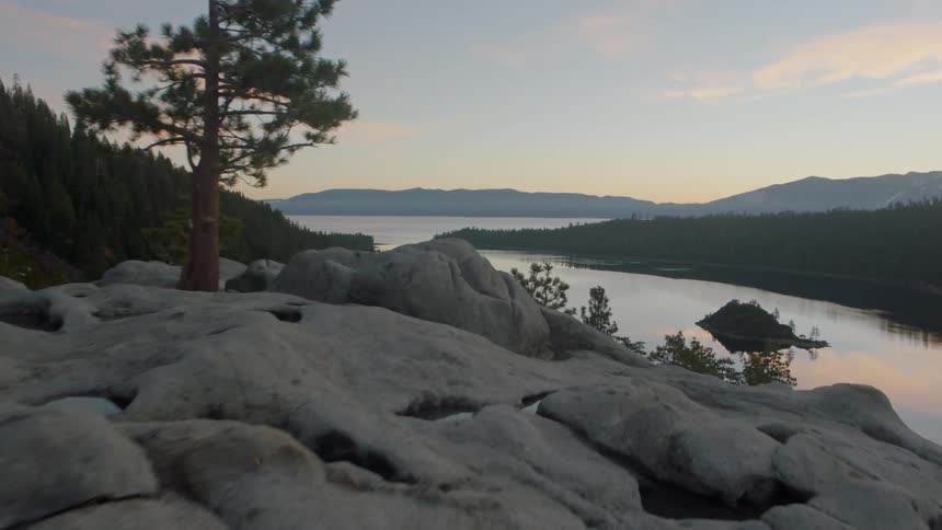 Flying over natural rock formations to reveal the calm waters of Lake Tahoe below