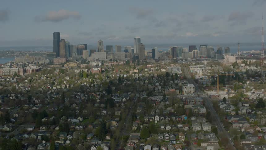 Houses stand before a city with tall buildings ahead