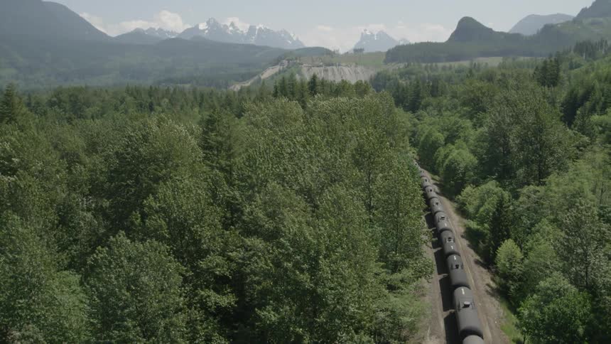 Crude oil freight train heading into the forest and mountains