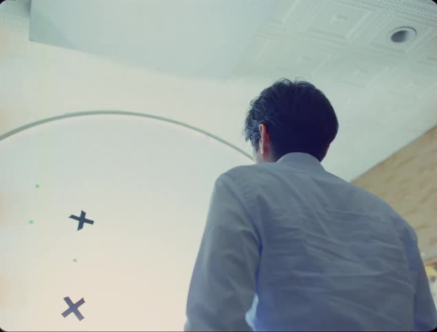 A man on blue shirt walking towards the wall