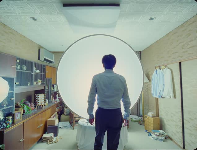 A man slowly approaches a mysterious circular object that emits light