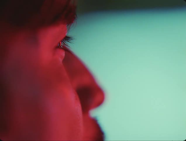 Profile of a man under red shifting lights