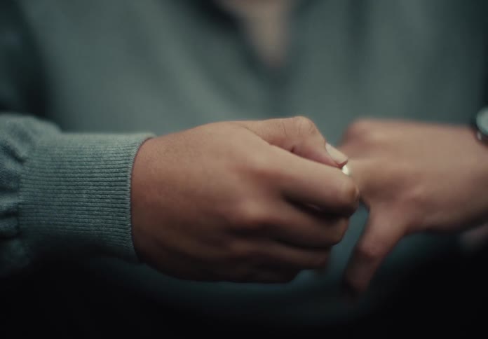 A man is touching his wedding ring