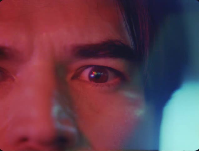 Close up of the eye of a man under red lights
