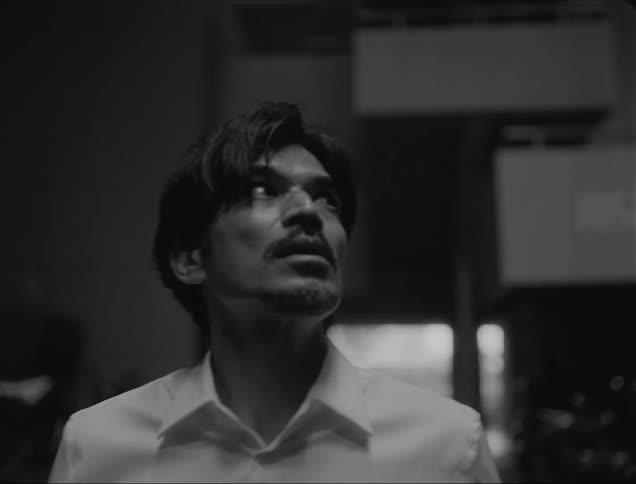 A man is walking as he looks up at the sky