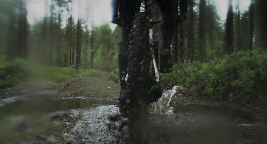 A person riding a bicycle in a muddy area and making it stand up