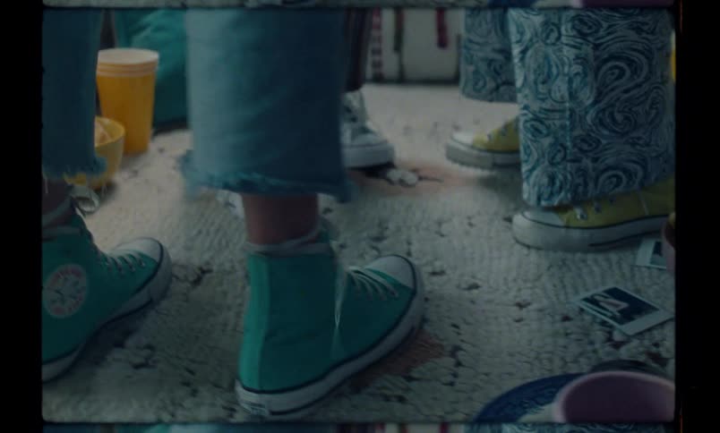 Closeup of the feet and legs of girls with drinks and food on the ground