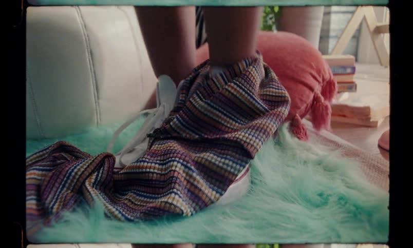 A young woman wearing tennis shoes quickly removes her pants