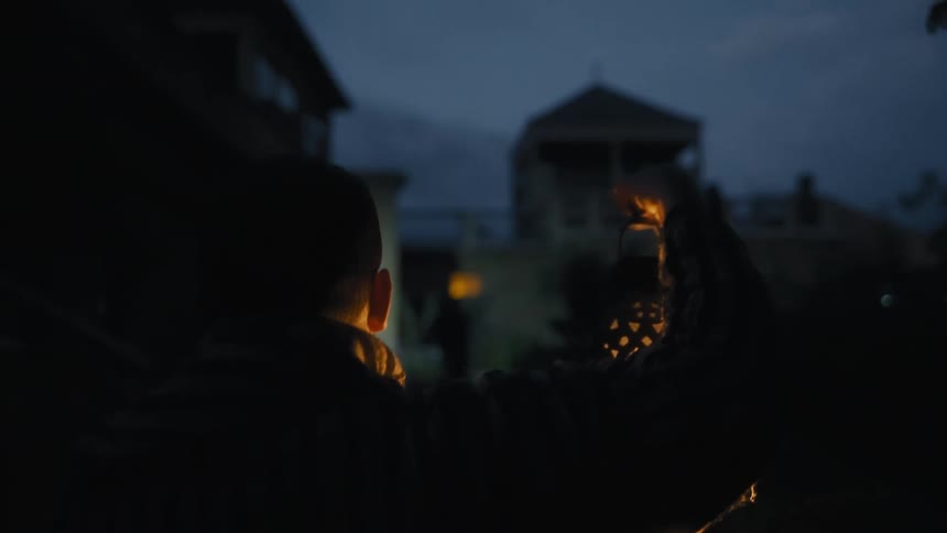 Man walking with a lantern in his hands facing away