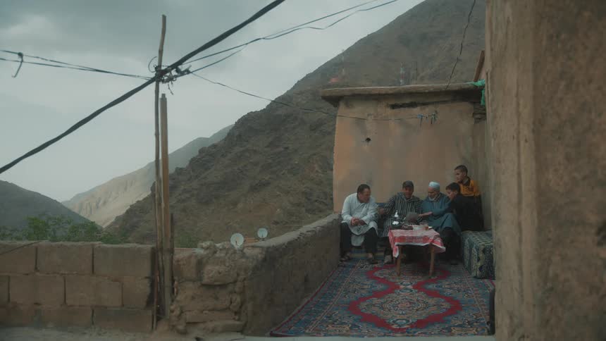 People sit at the balcony looking through pictures at sunset