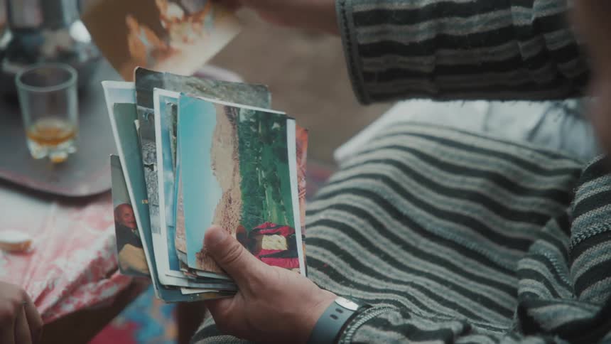 Closeup of the hands of an elderly person looking at photographs