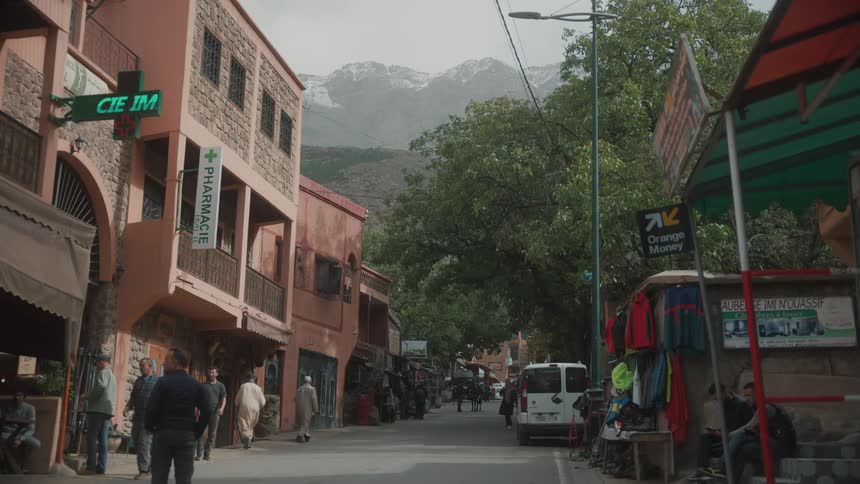 View of a street in the midst of a thirdworld city with snowcovered mountains in the background