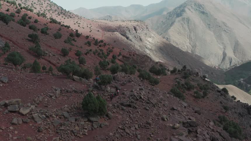 A group of people are walking on a large mountain