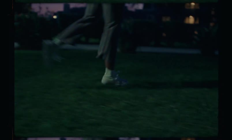 A young woman runs and then does a cartwheel atop some grass