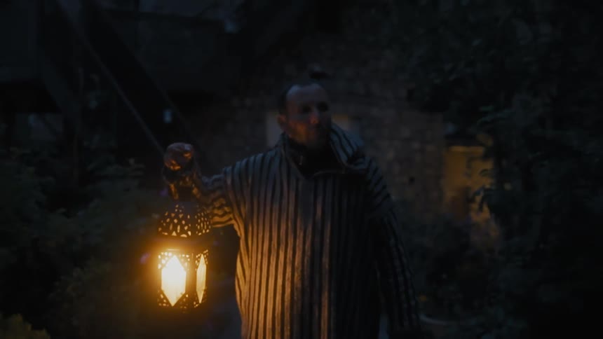 A man with a mask on walking with a lamp at night