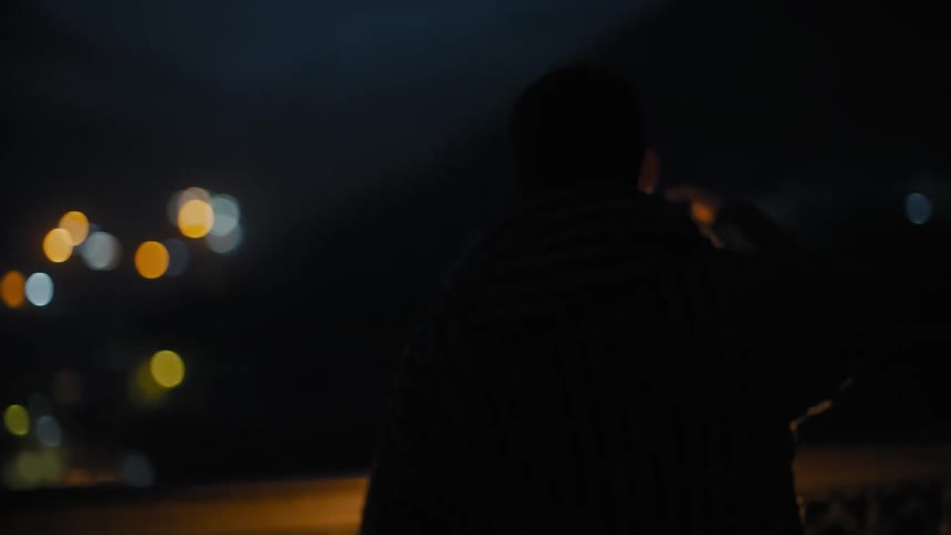 Man walking with a lantern at night and leaning it against a corner