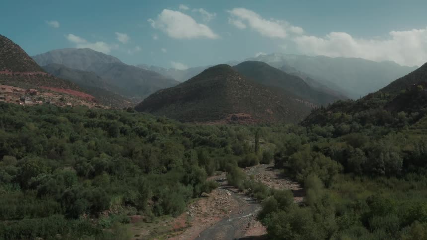 View of a mountain range with a small central river in the midst of a natural landscape