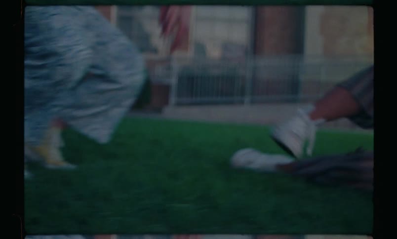 Girls squatting on the grass and a friend comes from behind and jumps over them